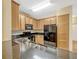 Kitchen features a large granite countertop, black appliances, and wood cabinets at 2011 Crestdale Ln, Lake Mary, FL 32746