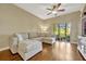 Comfortable living room with wood floors, neutral walls, modern ceiling fan, and a large window at 2011 Crestdale Ln, Lake Mary, FL 32746