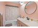 Charming pink bathroom with round mirror and tub-shower combo at 203 N Sweetwater Blvd, Longwood, FL 32779