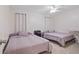 Cozy bedroom featuring two beds, soft carpet, and a ceiling fan for added comfort at 203 N Sweetwater Blvd, Longwood, FL 32779