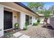 Inviting home entrance featuring a stylish front door, decorative plants, stepping stones, and gravel landscaping at 203 N Sweetwater Blvd, Longwood, FL 32779