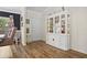 Bright foyer boasts hardwood floors, a white cabinet with glass doors, crown molding, and a view of the dining area at 203 N Sweetwater Blvd, Longwood, FL 32779