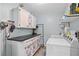 Well-equipped laundry room with cabinetry, utility sink, washer, and dryer at 203 N Sweetwater Blvd, Longwood, FL 32779