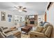 Cozy living room with brick fireplace, ceiling fan, and comfortable seating, open to the kitchen area at 203 N Sweetwater Blvd, Longwood, FL 32779