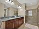 Bathroom featuring granite countertop, double vanity, and tile shower at 2319 Dammar St, Orlando, FL 32824