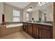Bathroom featuring double vanity, soaking tub, and tile flooring at 2319 Dammar St, Orlando, FL 32824