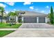 Charming home with a three car garage, well-manicured lawn, and lush landscaping for curb appeal at 2319 Dammar St, Orlando, FL 32824