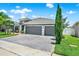 Attractive home featuring a three-car garage, vibrant lawn, and decorative landscaping at 2319 Dammar St, Orlando, FL 32824