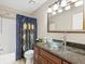 Showcases a clear glass bowl sink, granite countertop, and decorative shower curtain, enhancing the bathroom’s charm at 2550 N Alafaya Trl # 9201, Orlando, FL 32826