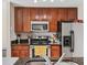 Highlights stainless steel appliances, including microwave, range, and refrigerator, with dark wood cabinets at 2550 N Alafaya Trl # 9201, Orlando, FL 32826