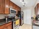 Modern kitchen with wood cabinets, black appliances, granite countertops and tile flooring at 2550 N Alafaya Trl # 9201, Orlando, FL 32826