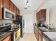 Kitchen featuring wood cabinets, black appliances, and granite countertops at 2550 N Alafaya Trl # 9201, Orlando, FL 32826