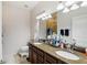 Bathroom features dual sinks, granite countertops, and recessed lighting, creating a functional space at 2628 Balforn Tower Way, Winter Garden, FL 34787