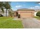 Inviting single-story home featuring a two-car garage and well-manicured front lawn with mature palm trees at 2628 Balforn Tower Way, Winter Garden, FL 34787