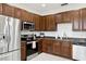Kitchen showcases modern stainless steel appliances and rich, dark wood cabinets for ample storage at 2628 Balforn Tower Way, Winter Garden, FL 34787