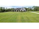 Charming two-story home with modern farmhouse design, black perimeter fencing, and a sprawling green lawn at 27071 Moss View Dr, Tavares, FL 32778