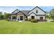 Charming farmhouse exterior with lush lawn, black roof, white siding, and welcoming front porch at 27071 Moss View Dr, Tavares, FL 32778