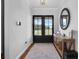 Bright foyer with black double doors, wood-look tile floors, rug, and stylish decor at 27071 Moss View Dr, Tavares, FL 32778