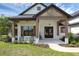 Inviting front porch featuring rocking chairs, wood beams, and a stylish entrance at 27071 Moss View Dr, Tavares, FL 32778