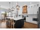 Modern kitchen with quartz countertops, black island, pendant lighting, and stainless-steel appliances at 27071 Moss View Dr, Tavares, FL 32778