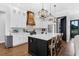 Stylish kitchen with white cabinets, a black island, stainless steel appliances, and modern pendant lighting at 27071 Moss View Dr, Tavares, FL 32778