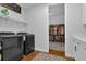 Functional laundry room with modern appliances, storage shelves, and convenient access to closet at 27071 Moss View Dr, Tavares, FL 32778
