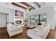 Inviting living room with a white brick fireplace and wood beams, complemented by comfortable seating at 27071 Moss View Dr, Tavares, FL 32778