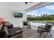 Covered patio featuring comfortable seating, a wall-mounted TV, and a view of the pool at 27071 Moss View Dr, Tavares, FL 32778