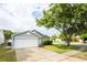 Residential house featuring well-maintained lawn, mature tree and a two-car garage at 302 Cello Cir, Winter Springs, FL 32708