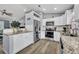 Bright kitchen features white cabinets, stainless steel appliances, and granite countertops at 3043 Mapleshade St, Deltona, FL 32738