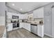 Well-lit kitchen with white cabinets, stainless steel appliances, granite countertops, and stylish backsplash at 3043 Mapleshade St, Deltona, FL 32738