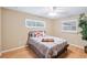 Cozy bedroom with wood floors, ceiling fan, and natural light from the windows at 3102 Cecelia Dr, Apopka, FL 32703