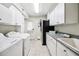 Well-equipped laundry room with white cabinets, sink, and modern appliances at 3102 Cecelia Dr, Apopka, FL 32703