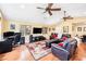 Large living room boasts vaulted ceilings, hardwood floors, a ceiling fan, and comfortable seating area with room for an office at 3102 Cecelia Dr, Apopka, FL 32703