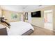 Spacious main bedroom with a large window, neutral carpet, and a ceiling fan that offers views into the ensuite bathroom at 3102 Cecelia Dr, Apopka, FL 32703