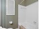 Cozy bathroom with striped wallpaper, white tile shower and tub at 3223 N Orange Ave, Orlando, FL 32803