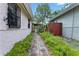 The side yard features a charming stone path and lush greenery, enhancing the home's curb appeal at 3223 N Orange Ave, Orlando, FL 32803