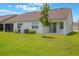 Spacious backyard features lush green grass, a tree, and a covered patio area at 3240 Canna Lily Pl, Clermont, FL 34711
