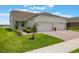 Charming home featuring a well manicured lawn, lush landscaping, and a convenient two-car garage at 3240 Canna Lily Pl, Clermont, FL 34711