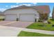This home features a two car garage and paver driveway at 3240 Canna Lily Pl, Clermont, FL 34711