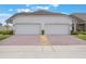 This home features a two car garage and paver driveway at 3240 Canna Lily Pl, Clermont, FL 34711