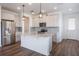 Well-lit kitchen with stainless steel appliances, a center island, pendant lights, and hardwood style flooring at 3240 Canna Lily Pl, Clermont, FL 34711