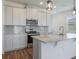 Modern kitchen with stainless steel appliances, gray backsplash, light cabinets, and hardwood style floors at 3240 Canna Lily Pl, Clermont, FL 34711