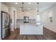 Spacious kitchen featuring stainless steel appliances, center island with granite countertop, and hardwood style flooring at 3240 Canna Lily Pl, Clermont, FL 34711