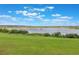 Scenic view featuring a large lake surrounded by lush green grass and vegetation at 3240 Canna Lily Pl, Clermont, FL 34711
