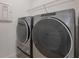 The laundry room has modern, high-end washer and dryer appliances and wire shelving at 3240 Canna Lily Pl, Clermont, FL 34711