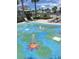 Colorful splash pad with fountains surrounded by lounge chairs and palms at 3240 Canna Lily Pl, Clermont, FL 34711