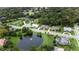 An aerial view of homes near a community pond with fountain, nestled among lush trees, with tennis courts nearby at 343 Leslie Ln, Lake Mary, FL 32746