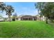 Spacious backyard with large grassy area leading to a screened-in pool and the home's rear facade at 343 Leslie Ln, Lake Mary, FL 32746