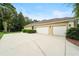Spacious three-car garage with extended driveway and lush greenery at 343 Leslie Ln, Lake Mary, FL 32746